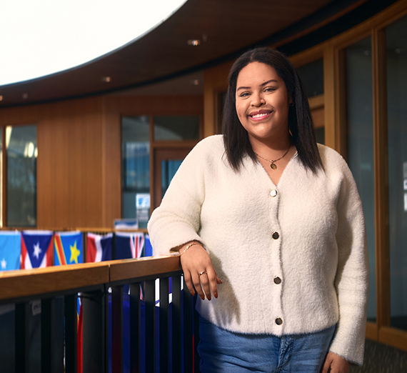 창가 옆에 팔을 교차한 채 서 있는 여성